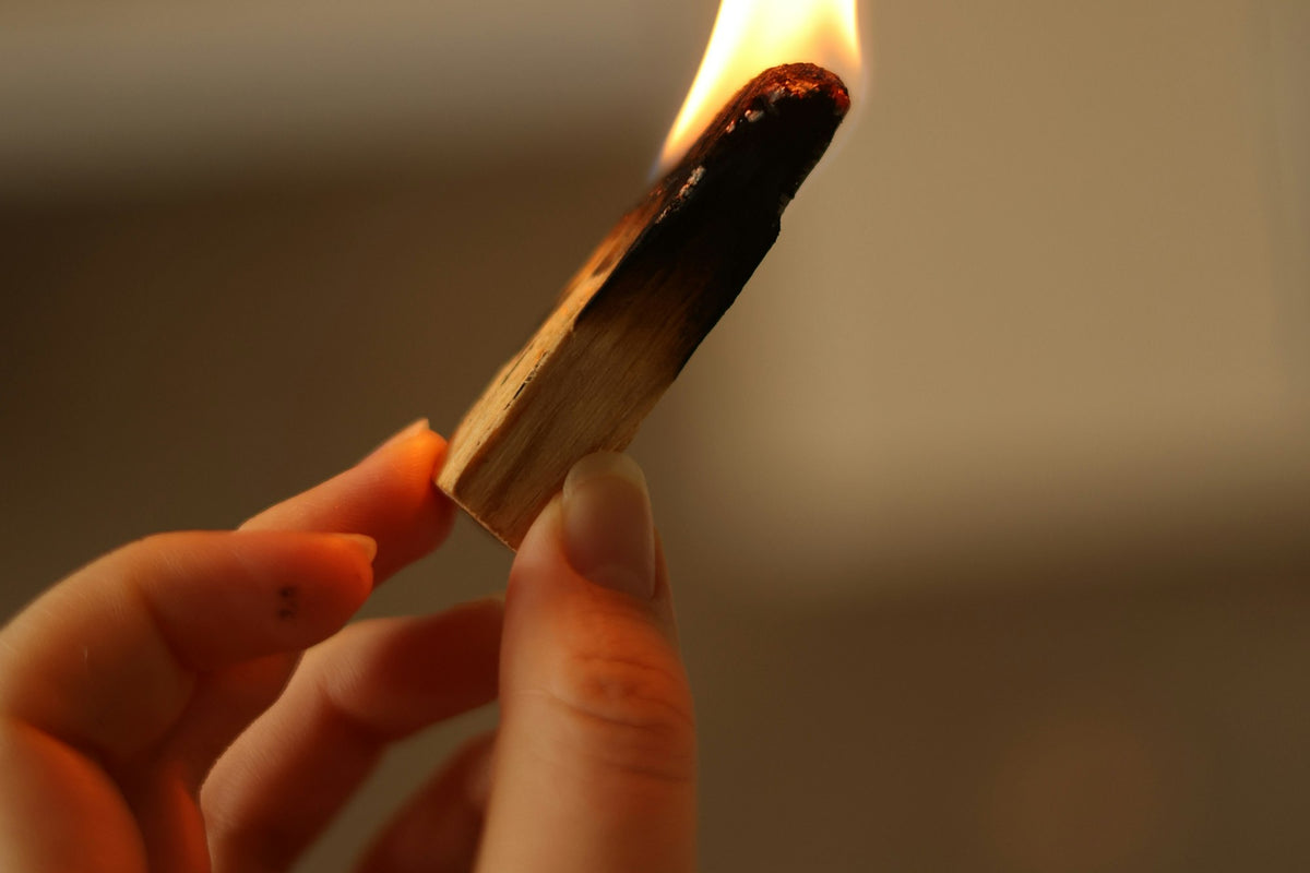 Yanan Palo Santo çubuğu ile doğal taş kolyenin enerjisini arındırma ritüeli
